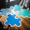 People holding puzzle pieces together